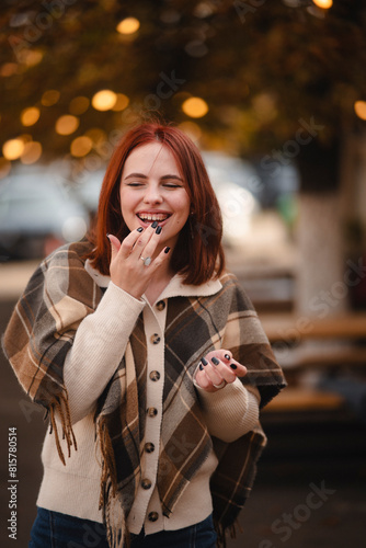 A cheerful redhead beams with joy on the streets of the autumn city.