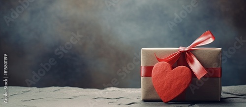 A beautiful gift box with a red heart and paper card on a retro background featuring a rock Perfect for a sentimental occasion or celebration Copy space image photo