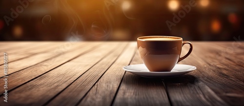 A cup of coffee placed on a wooden table with enough space around it in the image for any additional elements photo