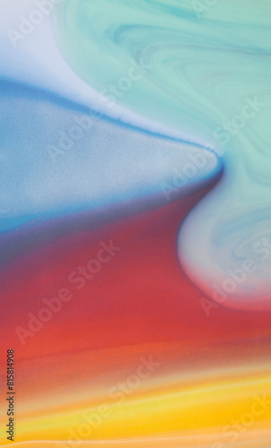 Vibrant acrylic paint flowing downwards on a surface, creating a colorful and dynamic abstract pattern.