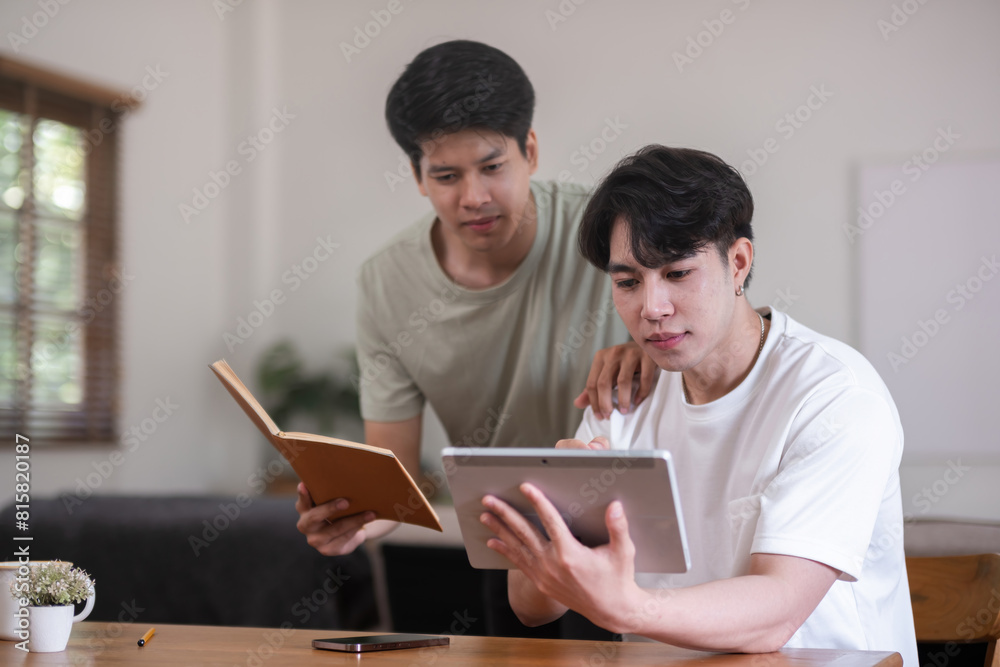 A male lgbt couple is studying together while studying online at home to prepare for an online exam. A male lgbt couple is studying together while studying online at home to prepare for an online exam.