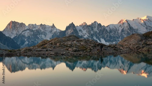 Landscape of Lac Blanc with Mont Blanc massif and male tourist reflect on the lake among French Alps in the morning at Chamonix Mont Blanc