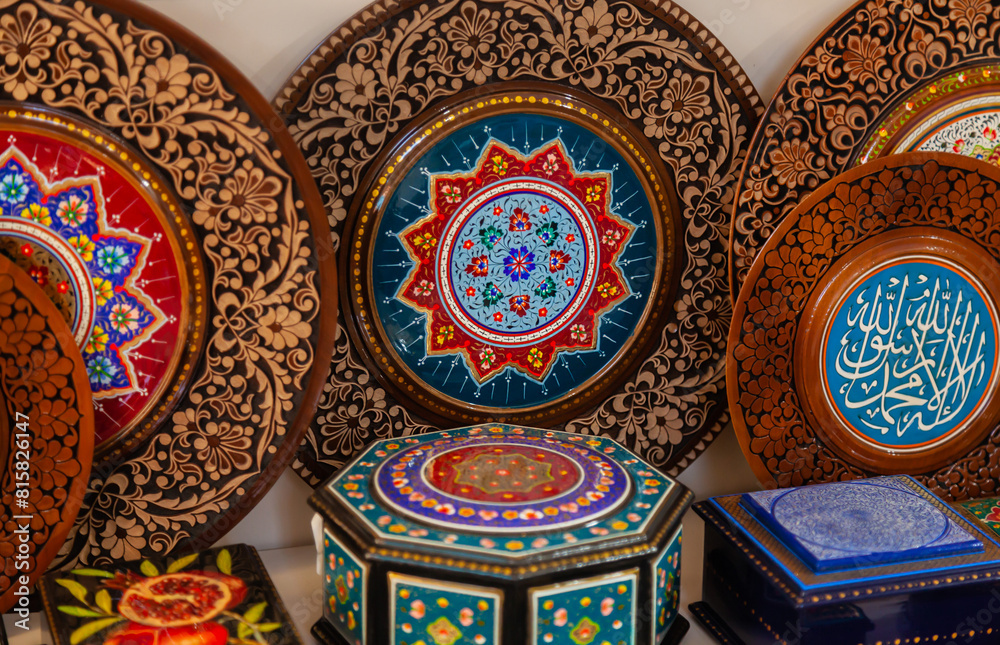 handmade Uzbek wooden plates with wood carvings hand-painted traditional patterns in the souvenir shop of Uzbekistan