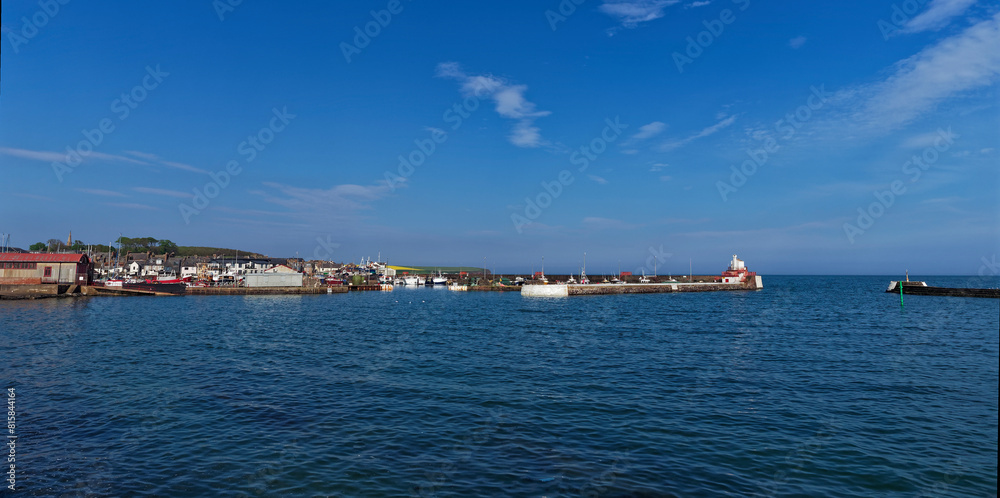A view of Arbroath Harbour with the Signal Lighthouse and West Breakwater leading to the Tidal harbour Entrance with Fishing Boats moored up.