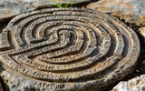 Ancient stone labyrinth engraving with inscribed Latin text.