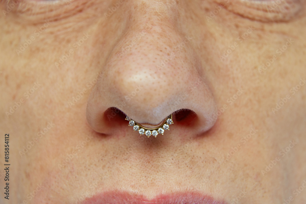 Close-up image of male face with focus on nose with piercing. Textured skin with pores. Concept of natural beauty, skincare, cosmetics and cosmetology