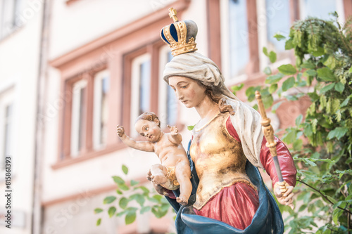 Heiligenfigur Maria mit Kind mit Zepter und Krone  vor Häuserkulisse  in Villingen an Fronleichnam photo