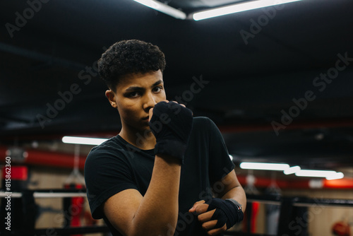 Strong young boxer, in boxing club, looking at camera.