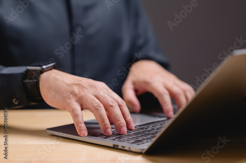 A man is typing on a laptop computer