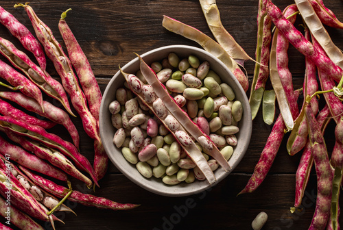 Group of borlotti beans, in a bowl on wooden table. View from above.