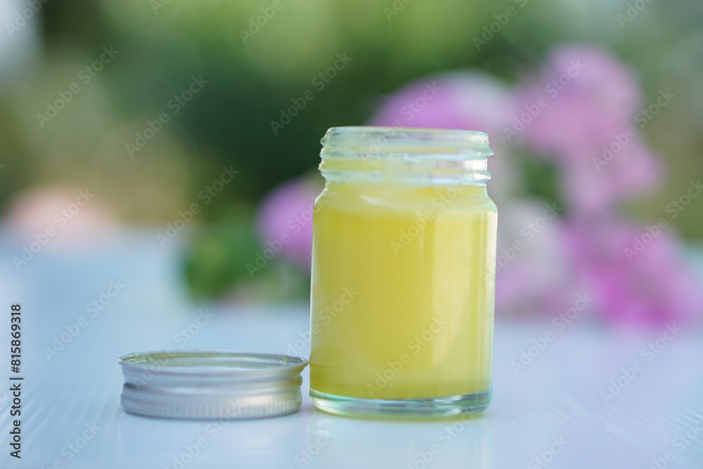 Bottle of homemade Thai herbal yellow ointment, balm.Decorated with flower. Concept, Thai local wisdom to use fragrant medicinal herbs to make inhaler and massage balm. Bottle of homemade Thai herbal yellow ointment, balm.Decorated with flower. Concept, Thai local wisdom to use fragrant medicinal herbs to make inhaler and massage balm.