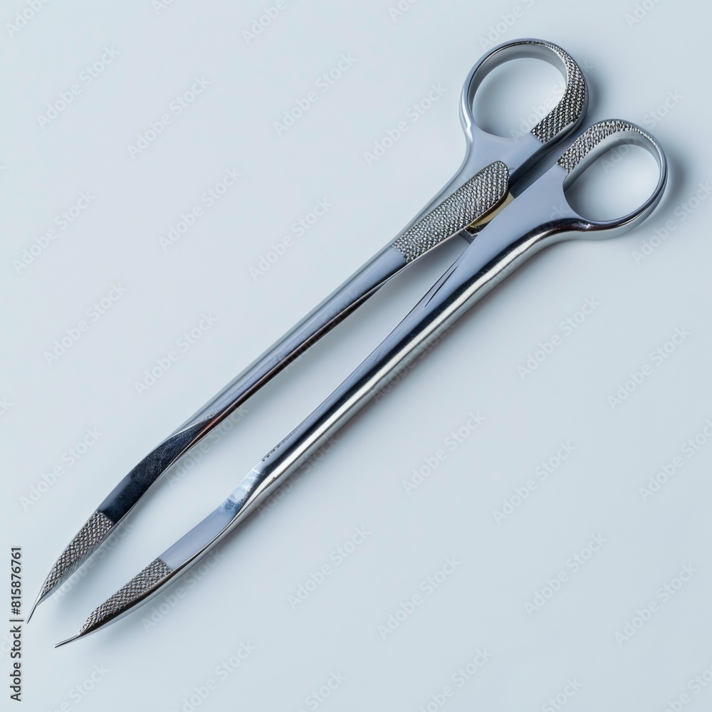 A pair of stainless steel medical scalpel and scissors on a white background A pair of stainless steel medical scalpel and scissors on a white background