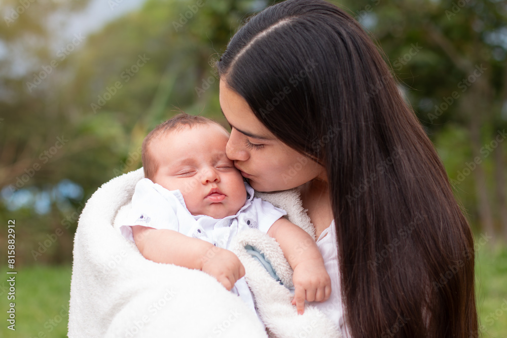 lifestyle: mother kisses her sleeping baby's face lifestyle: mother kisses her sleeping baby's face