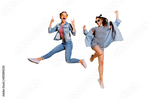 Full legs body size two attractive music lover leisure lifestyle cool lady isolated on yellow vivid background in glasses spectacles dance dancer on concert raised fists up give heavy metal gesture