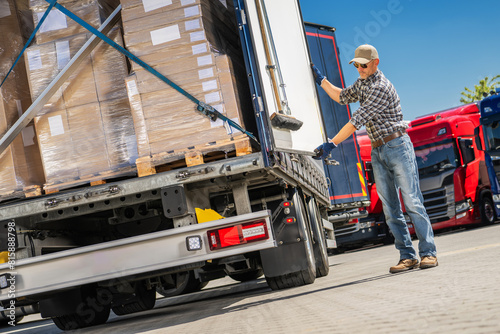 Trucker Loading Cargo Boxes Into Truck © Tomasz Zajda