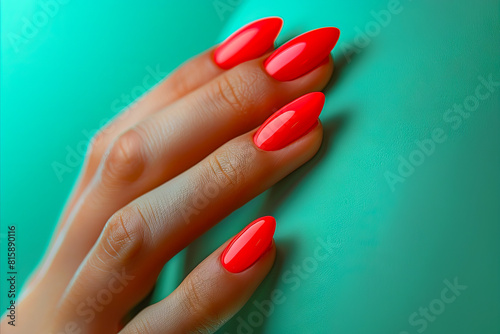 A woman with red nails and a green background.