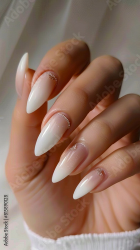 A woman s hand with white and white stiletto nails.