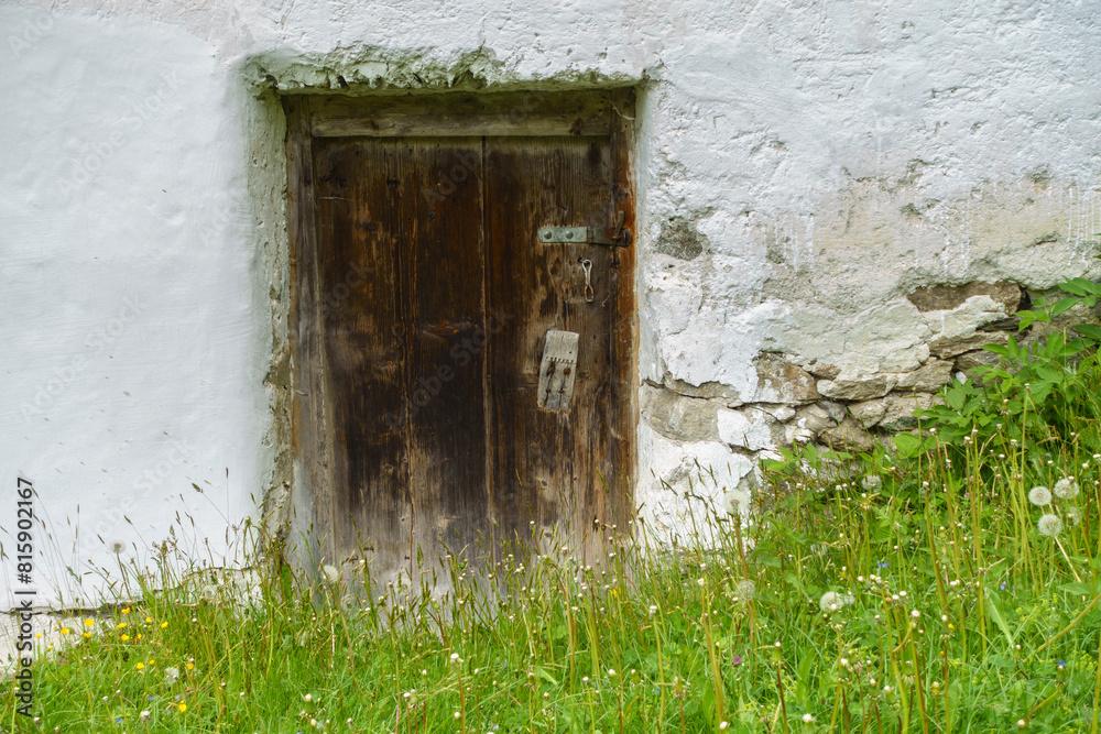 Eine alte dunkle Holztür in rustikalem Gemäuer als idealer Hintergrund Eine alte dunkle Holztür in rustikalem Gemäuer als idealer Hintergrund