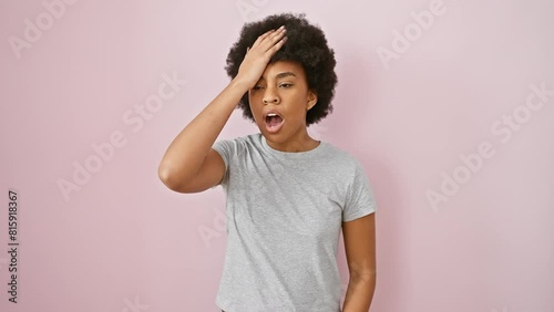 Black, curly african american woman in t-shirt, standing clueless with hand on head, annoying memory error. regretting foolish blunder, forgot something important. isolated on pink background. photo