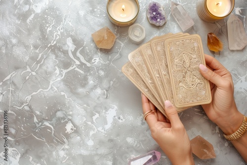 woman hands holding tarot cards, fortune telling, prophecy reading concept, top view esoteric magical layout with crystals, oracle and candles