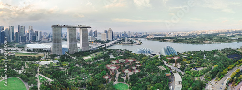 Marina Bay in Singapore features the iconic Marina Bay Sands, Gardens by the Bay, Helix Bridge, and the Singapore Flyer. It offers stunning views of modern architecture, lush greenery, and the vibrant © yihchang