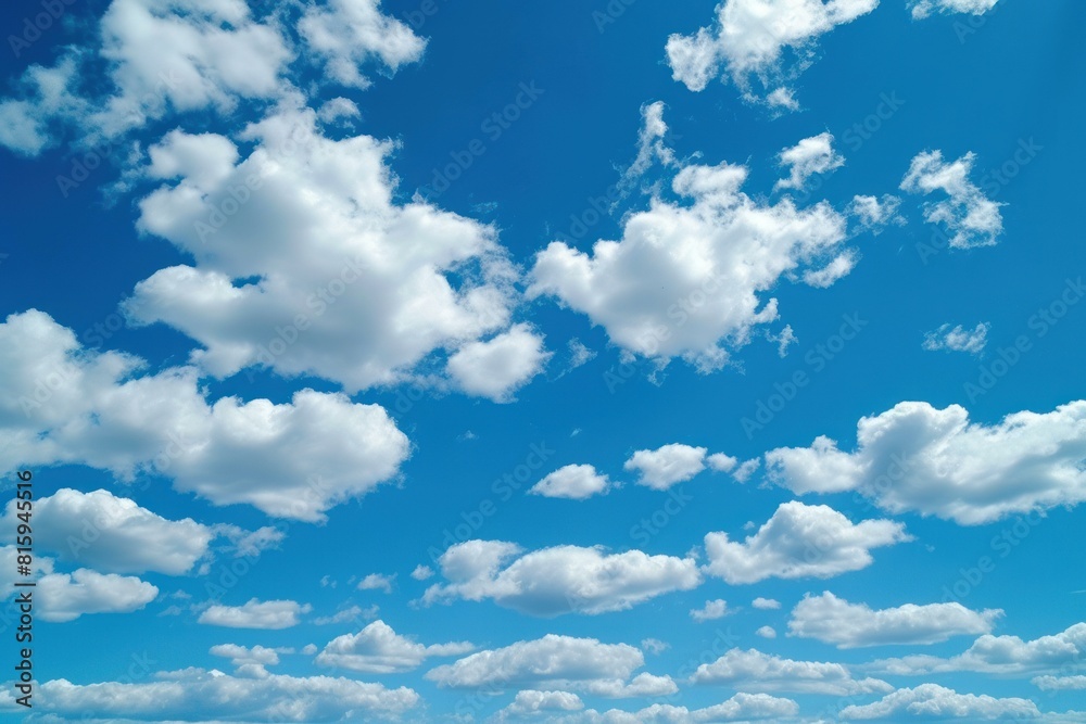 Vibrant blue sky dotted with soft white cumulus clouds, depicting calmness Vibrant blue sky dotted with soft white cumulus clouds, depicting calmness