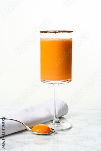 Glass with orange and egg yolk smoothie. Invigorating shake with proteins and vitamins...