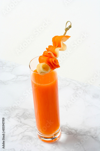 Glass with carrot and melon juice, on a white marble background...