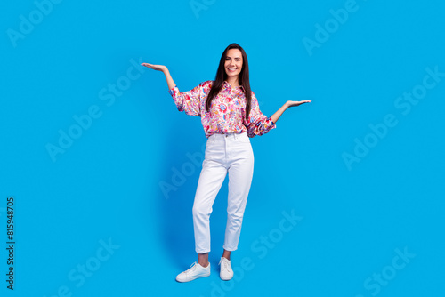 Full length photo of cute adorable lady dressed print blouse showing arms scales emtpy space isolated blue color background photo