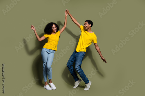 Full body portrait of two nice people dance good mood wear t-shirt isolated on khaki color background