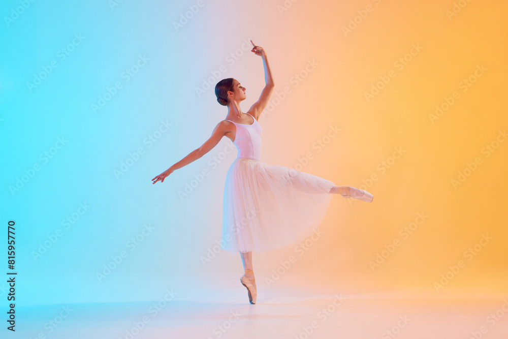 Fototapeta premium Graceful, tender ballerina performing pirouette in motion in neon light against blue-orange gradient background. Concept of art, movement, classical and modern fusion, beauty and fashion. Ad