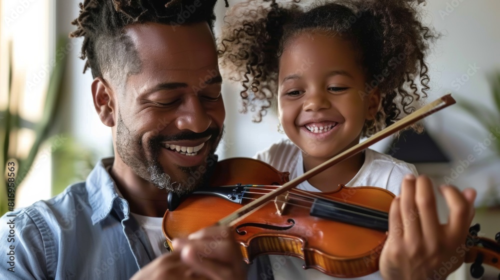 Father and daughter enjoying time together, with the father teaching the little girl how to play the violin. Father and daughter enjoying time together, with the father teaching the little girl how to play the violin.