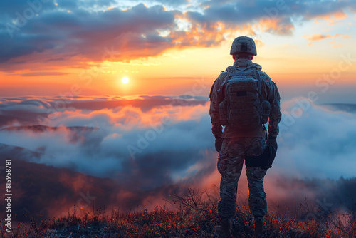 Soldier watching a sunrise over mist-covered hills, symbolizing hope and resilience