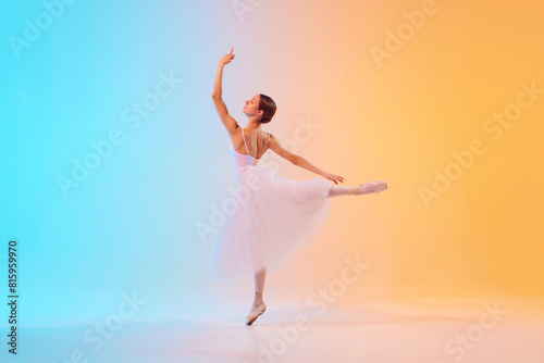 Dynamic photo of ballet dancer extends her arm elegantly dressed in pale tutu in neon light against blue-orange gradient background. Concept of art, movement, classical and modern fusion, beauty. Ad