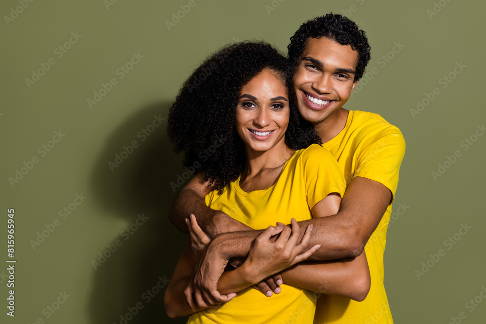 Portrait of two nice people embrace empty space wear t-shirt isolated on khaki color background Portrait of two nice people embrace empty space wear t-shirt isolated on khaki color background