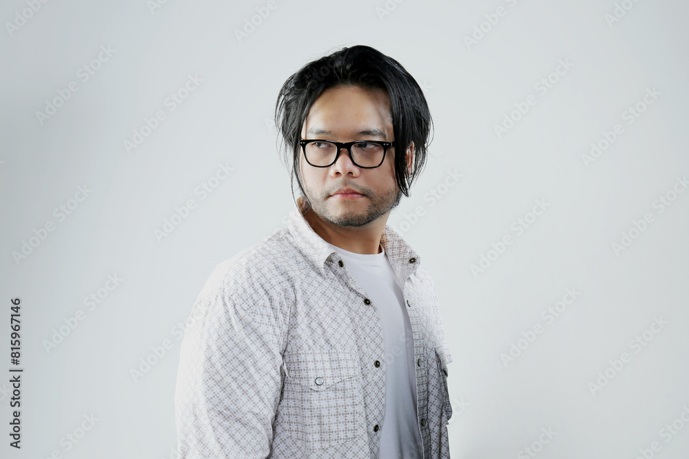 Portrait of Asian man standing with serious expression looking back on white background Portrait of Asian man standing with serious expression looking back on white background