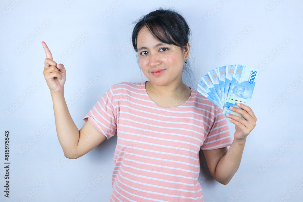 Portrait of a young asian woman holding cash money while pointing empty space. Advertisement concept Portrait of a young asian woman holding cash money while pointing empty space. Advertisement concept