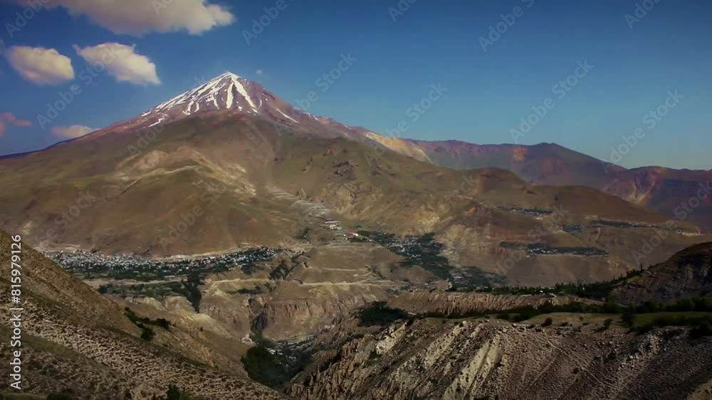 Long shot of the grandeur of Mount Damavand in all its summer splendor, surrounded by a beautifully diverse landscape. Long shot of the grandeur of Mount Damavand in all its summer splendor, surrounded by a beautifully diverse landscape.