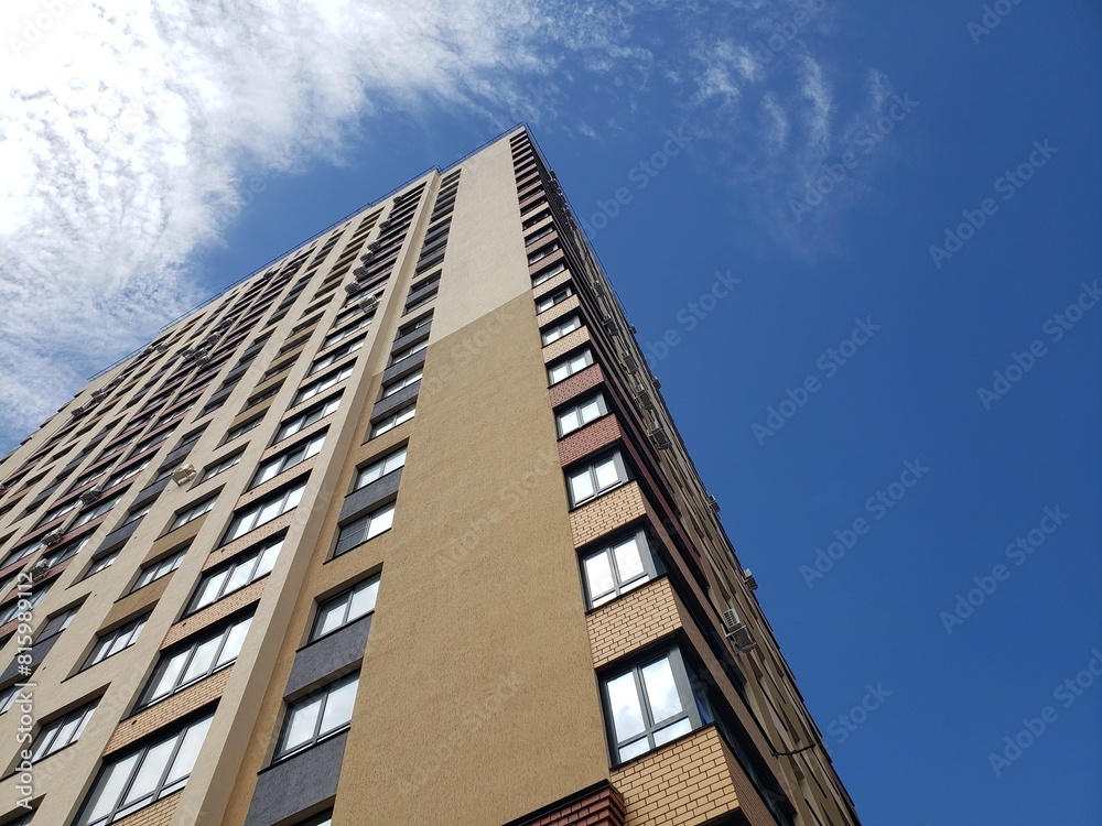 high-rise apartment building against the blue sky. Typical developments in residential areas.