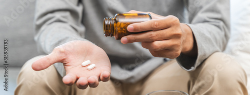 фотографія Close-up a medicine tablet in young man hand taking painkiller