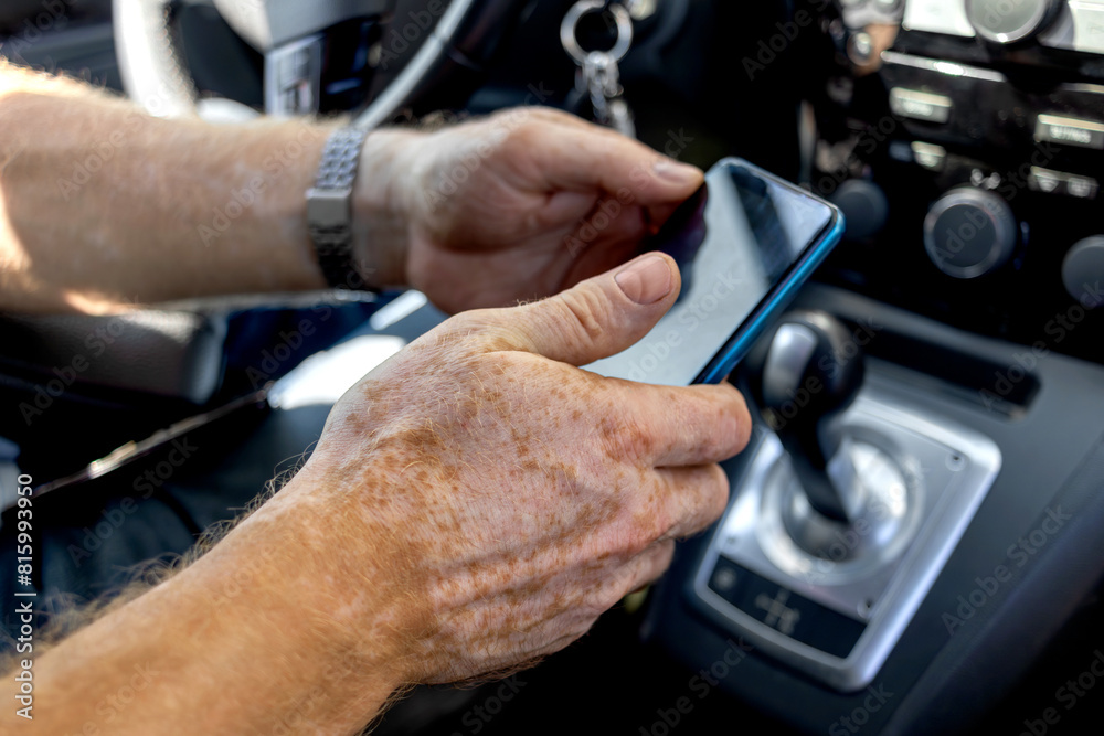 Man texting in car from his cell phone. Close-up of hands with Vitiligo. Problem skin. Lifestyle Man texting in car from his cell phone. Close-up of hands with Vitiligo. Problem skin. Lifestyle