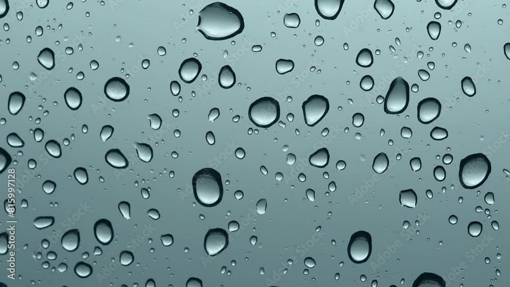 Window with raindrops on it. The drops are small and scattered, which creates a sense of movement and fluidity. The scene is calm and peaceful as the raindrops seem to fall gently. Window with raindrops on it. The drops are small and scattered, which creates a sense of movement and fluidity. The scene is calm and peaceful as the raindrops seem to fall gently.