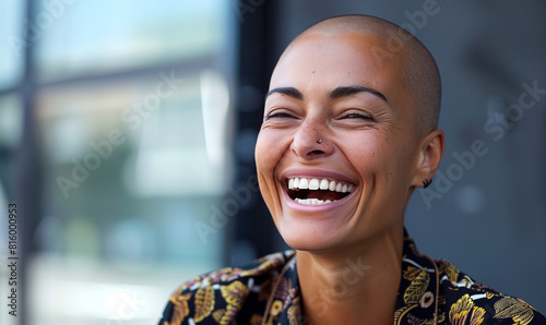 Happy candid bald woman laughing. Inclusive image of mixed race businesswoman with alopecia hair loss condition. Inclusion & diversity in workplace photo
