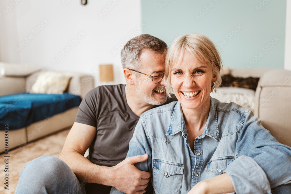 Joyful senior couple laughing and enjoying each other's company while relaxing at home on a cozy afternoon. Joyful senior couple laughing and enjoying each other's company while relaxing at home on a cozy afternoon.