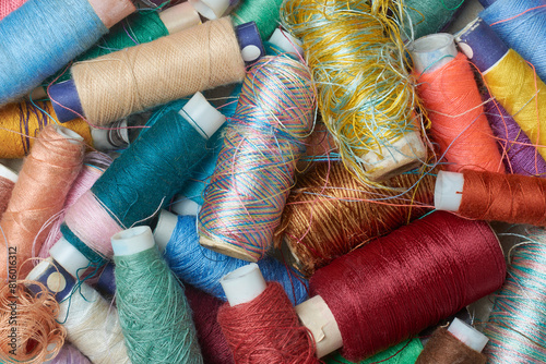 spool of sewing thread used in fabric and textile industry, multi or different colors, full frame background taken from above