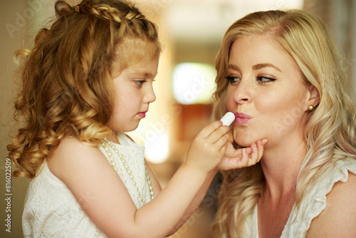 Lipstick  mother and child with makeup in home for beauty  care or family bonding together. Girl  mom and kid apply lip cosmetics on face  playing or parent teaching to paint for help in bathroom