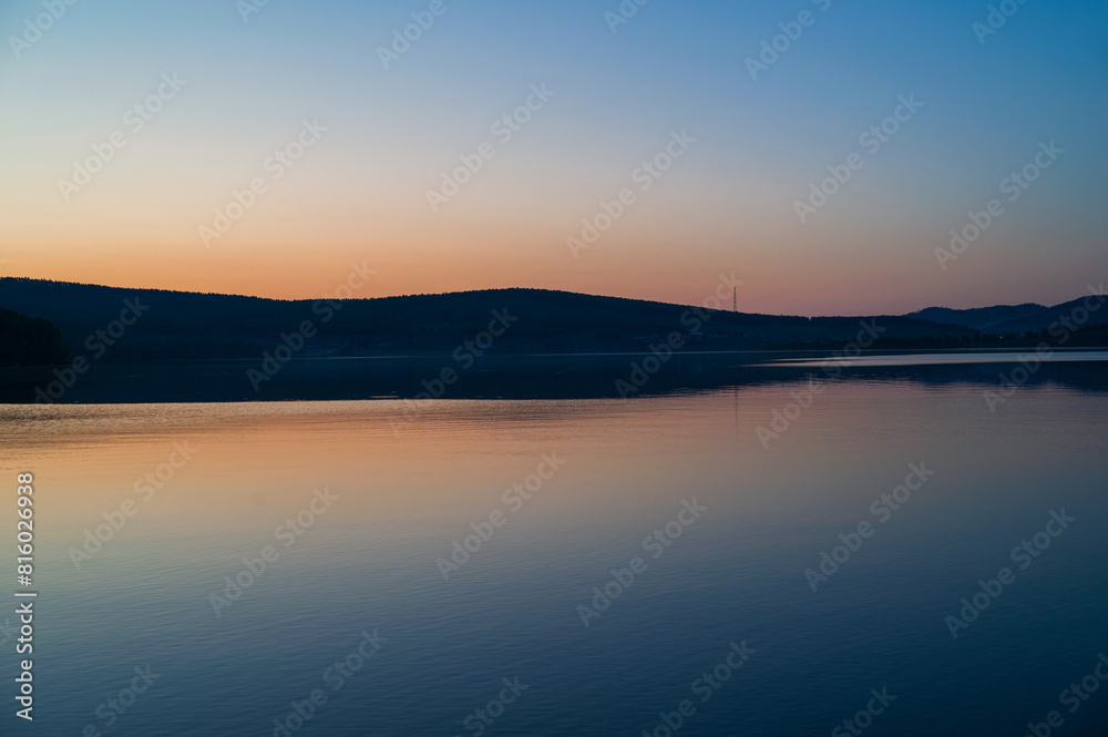 A calm and silent evening at sunset at the summer lake