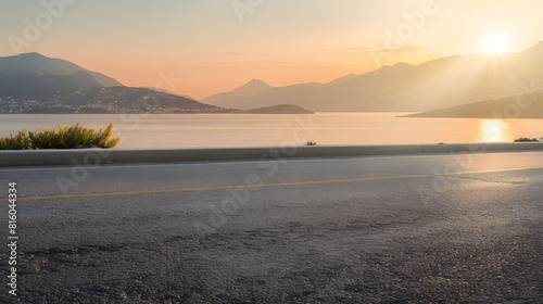 Fototapeta Naklejka Na Ścianę i Meble -  Empty asphalt road and sea with mountain scenery at sunset : Generative AI
