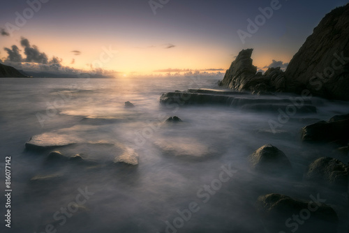 Sunset on Azkorri or Gorrondatxe beach  in Getxo  Bizkaia  with the waves passing over the rocks