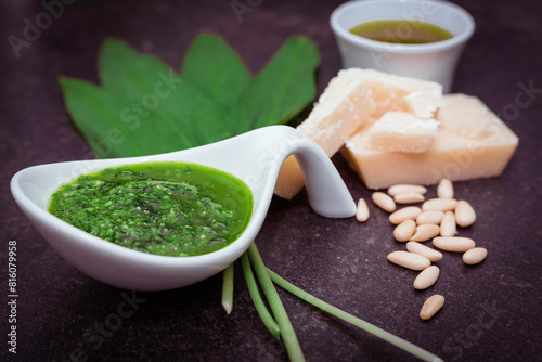 Ingredients for a wild garlic pesto. With a result of the pesto in the foreground.